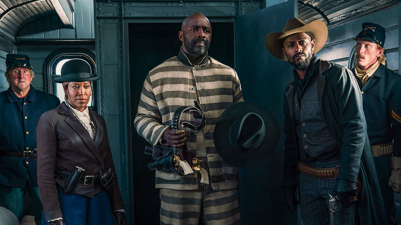 Rufus Buck (Idris Elba) is broken out of a traveling jail cell on a train by Trudy Smith (Regina King) and Cherokee Bill (LaKeith Stanfield) in The Harder They Fall
