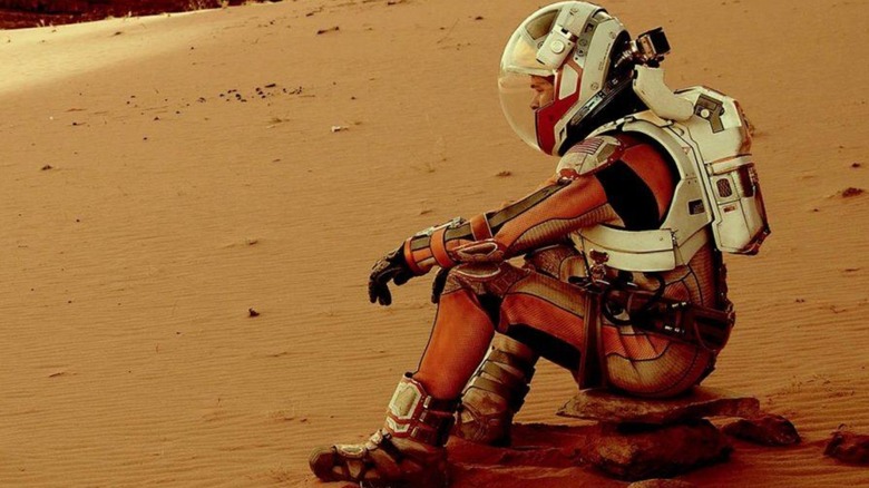 Dr. Mark Watney sitting on the Martian surface in 
