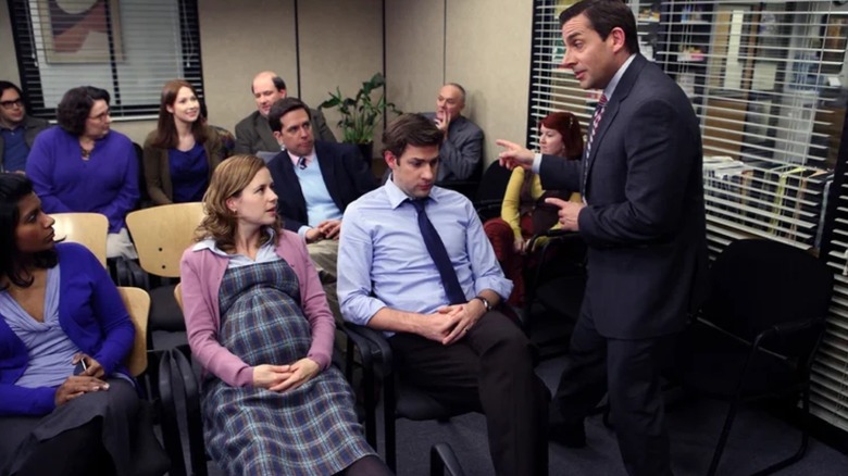 Michael Scott (Steve Carell) talking to the Dunder Mifflin team in the conference room in The Office