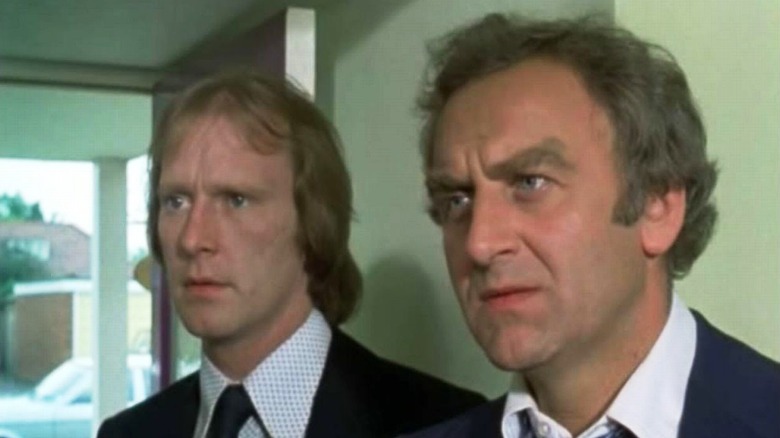Detective Sergeant George Hamilton Carter (Dennis Waterman) and Detective Inspector Jack Regan (John Thaw) stare down some subjects in The Sweeney