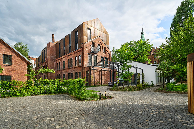 corten steel extends former laundry complex’s brick buildings in kassel