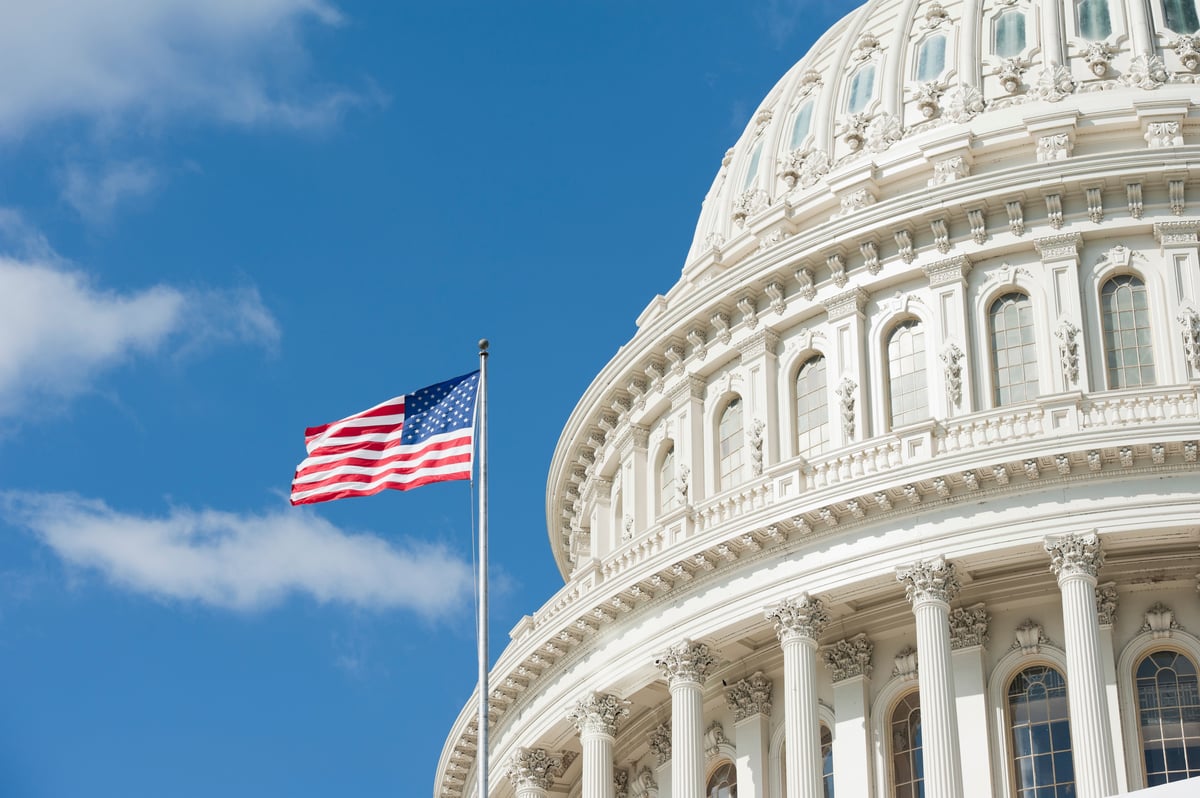 An American flag flying high next to the Capitol building in Washington, D.C.