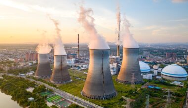 Aerial view of a nuclear power plant with four cooling towers steaming.