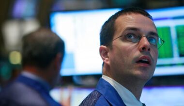 A New York Stock Exchange floor trader looking up in awe at a computer monitor.