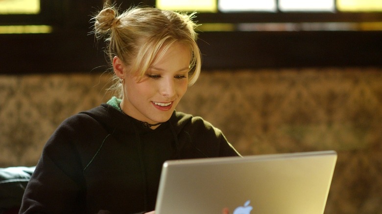 Kristen Bell with hair in buns looking at Macbook in Veronica Mars