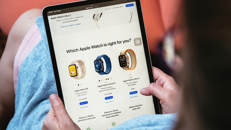 A woman browsing the Apple website on an iPad to select the right model of Apple Watch for them