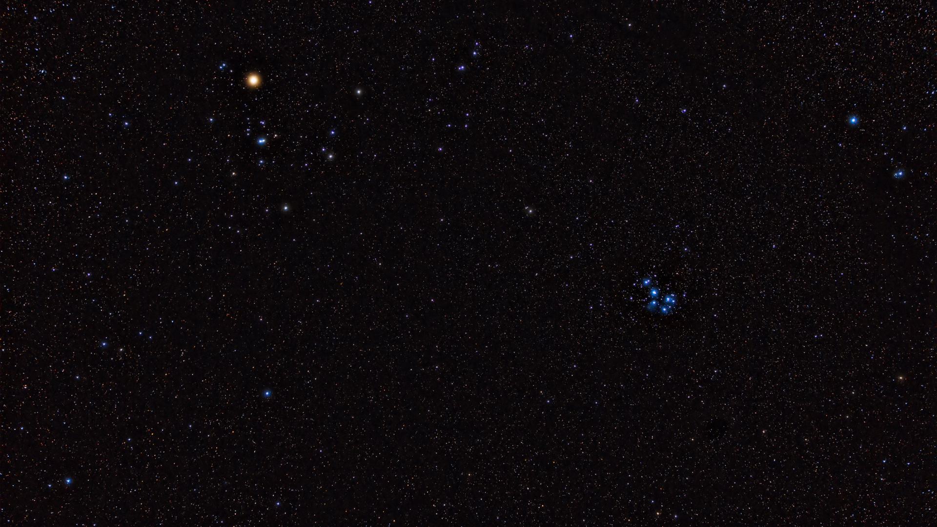 A cluster of bright blue dots of stars against a deep space background