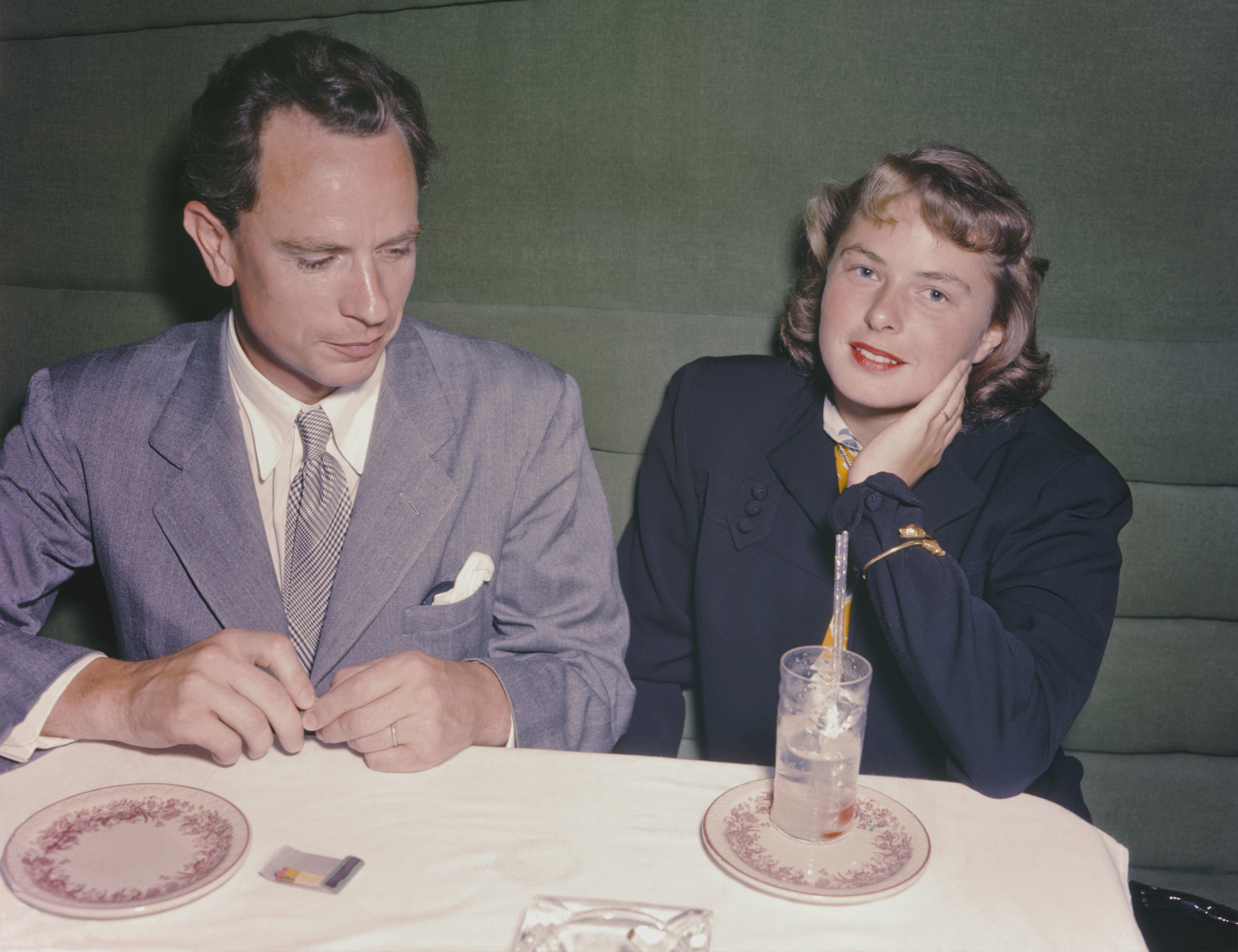 Actress Ingrid Bergman and her husband Petter Lindstrom at a dinner table.