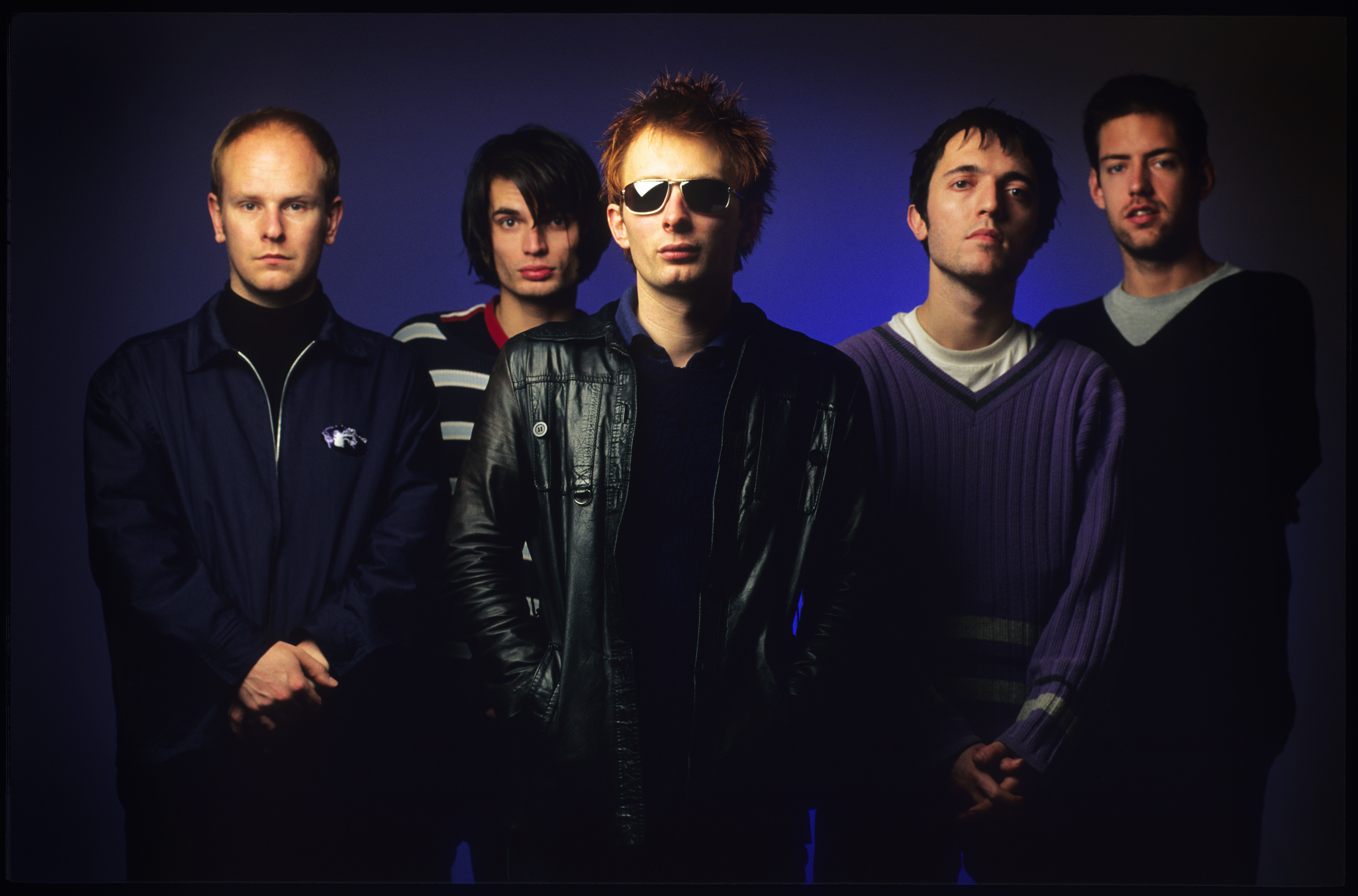 Radiohead band members Phil Selway, Jonny Greenwood, Thom Yorke, Colin Greenwood, and Ed O'Brien pose for a photo.