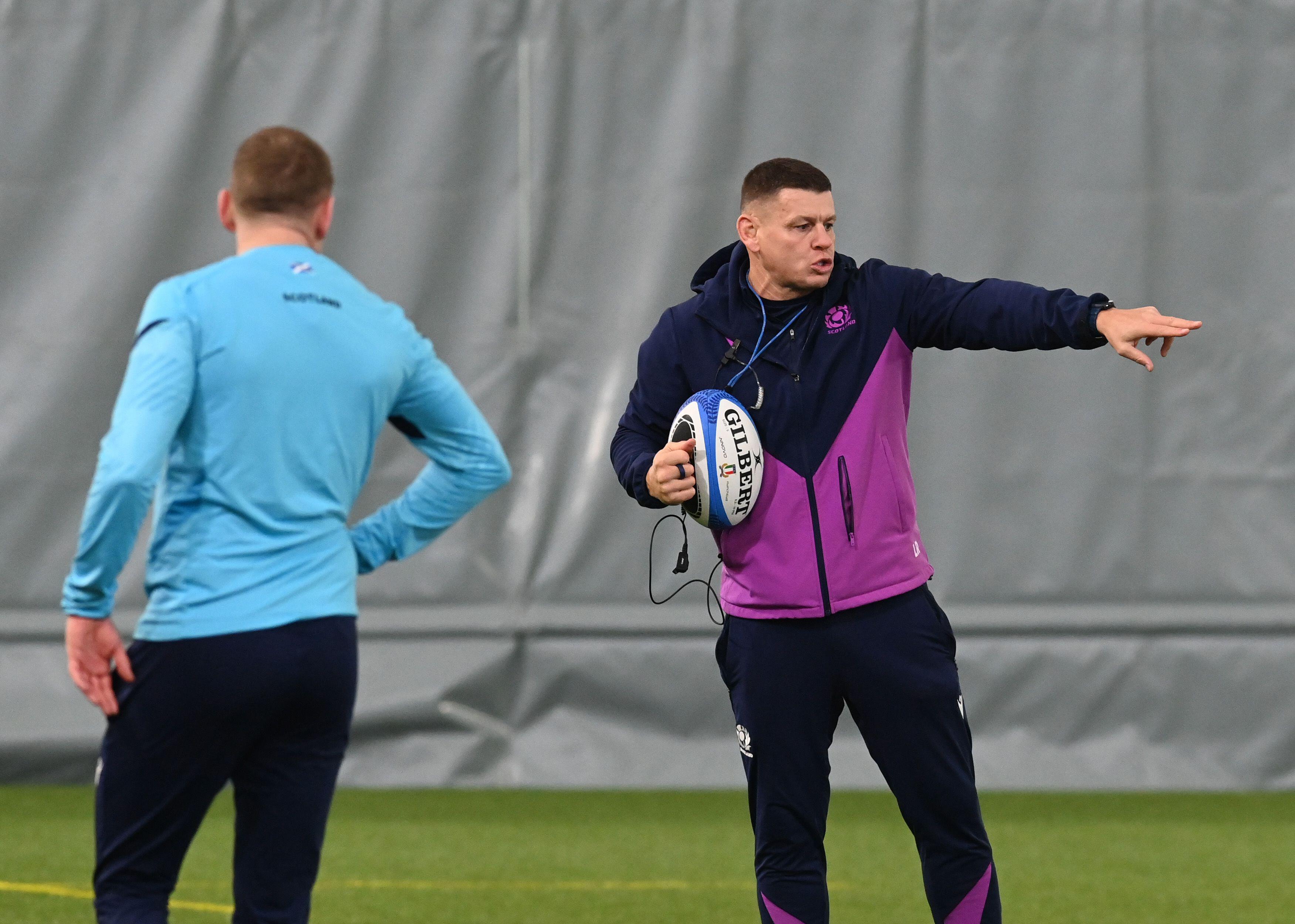 Scotland Assistant Coach Lee Radford holding a rugby ball and pointing during a training session.