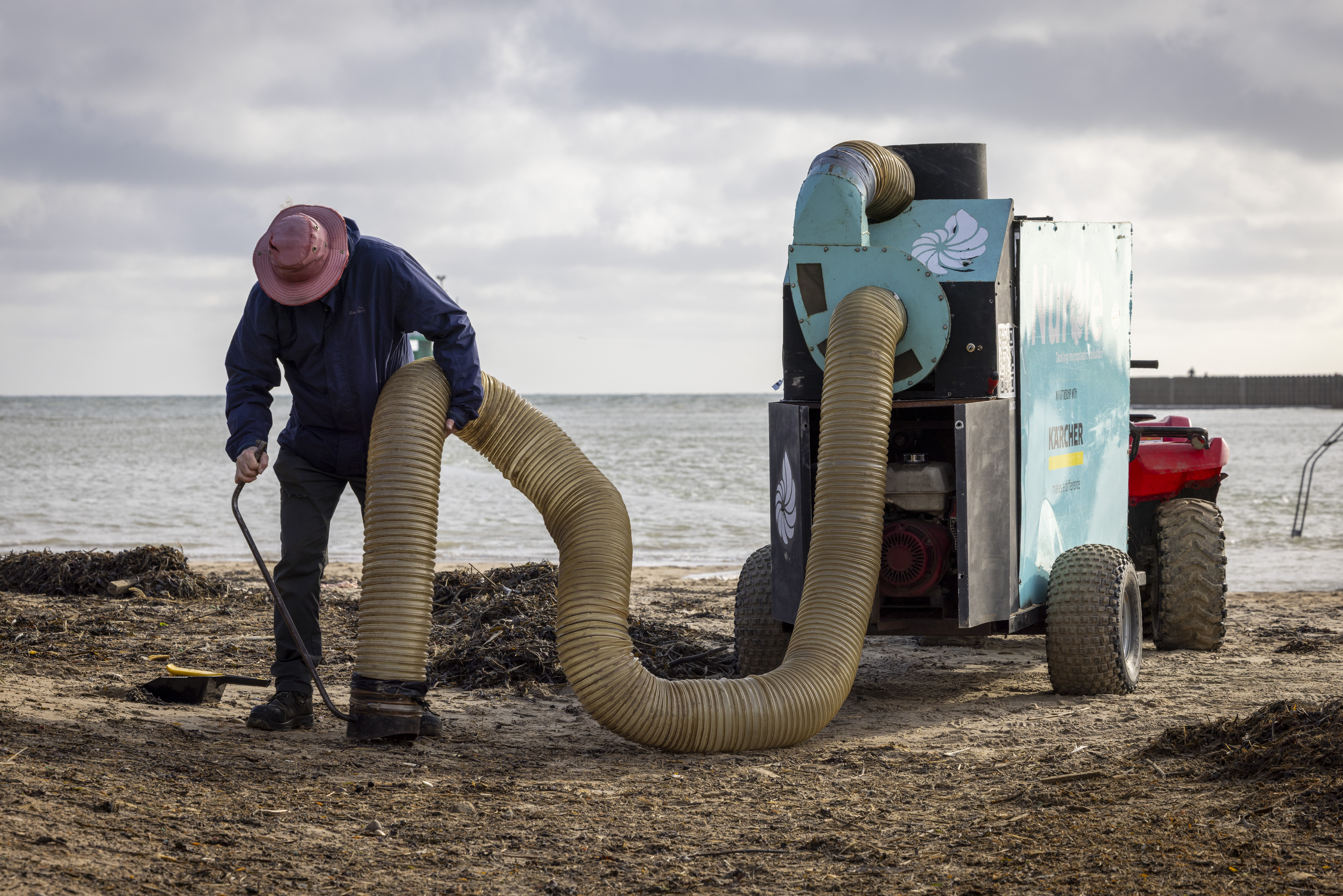 A man uses a Nurdle Coast machine to clean plastic bio-beads from a beach.