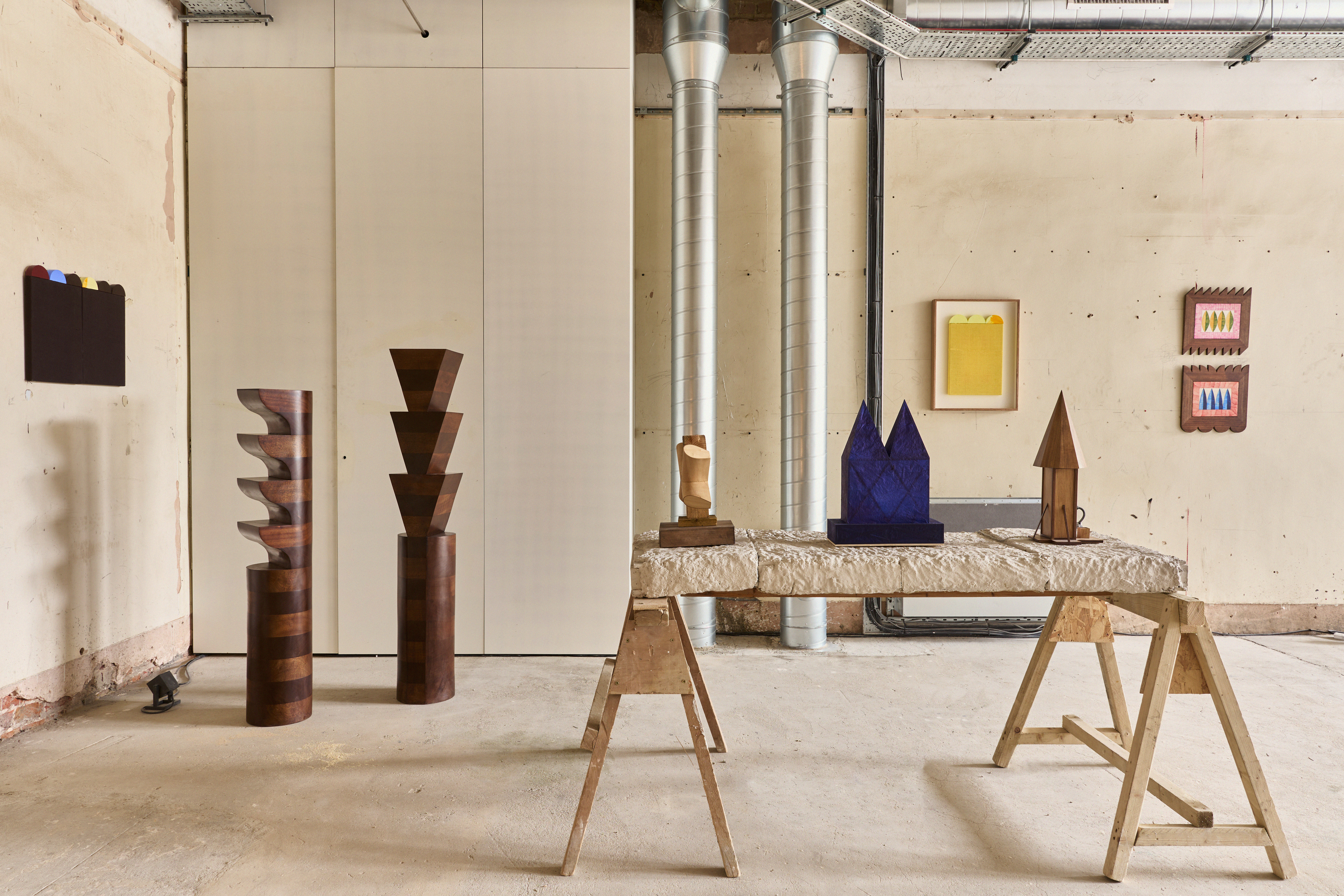 Various geometric sculptures and artwork displayed in an industrial-style room.