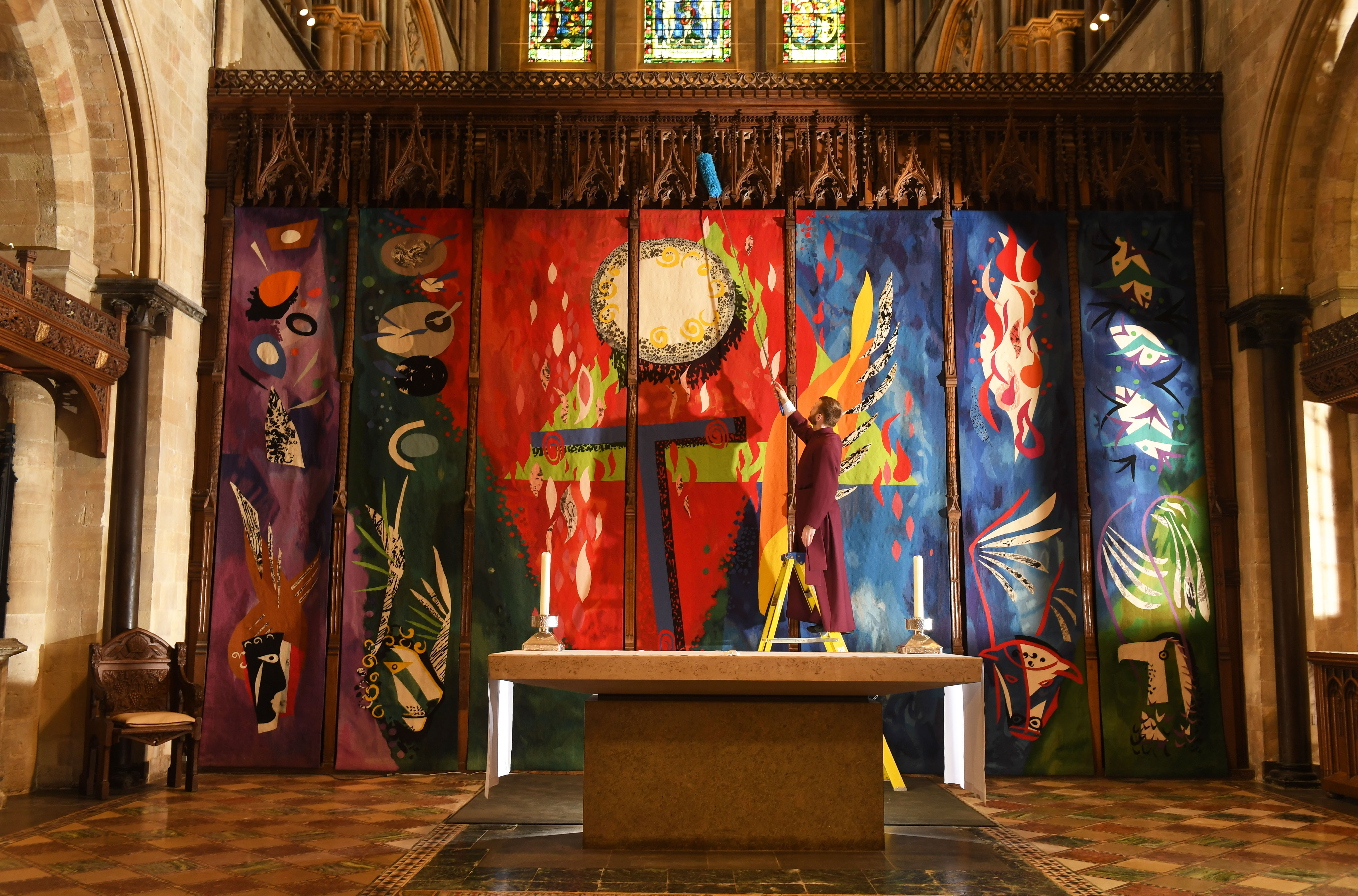 Verger Rob Bond dusting the John Piper tapestry at Chichester Cathedral.