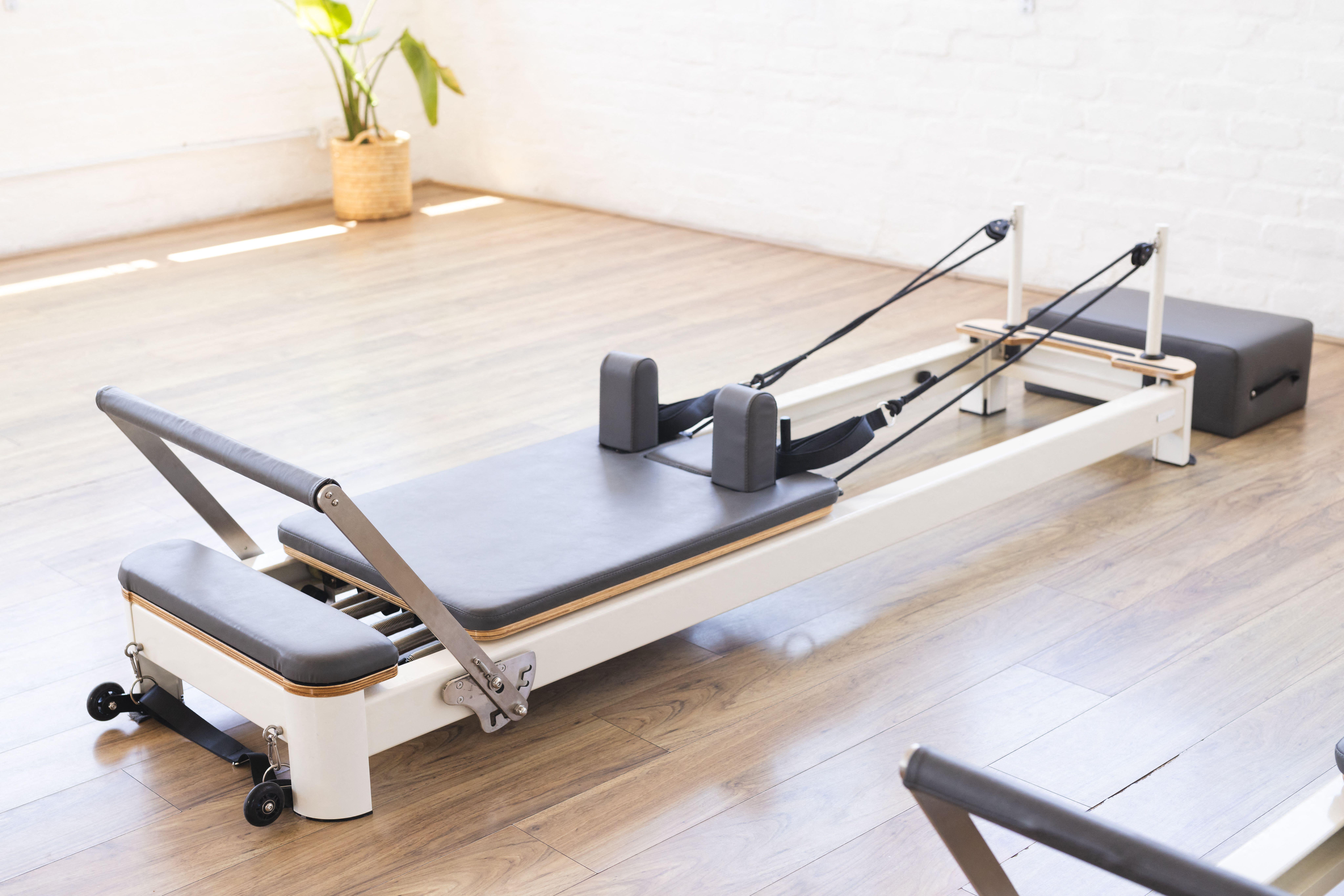 A Pilates reformer machine ready for a workout in a bright studio.