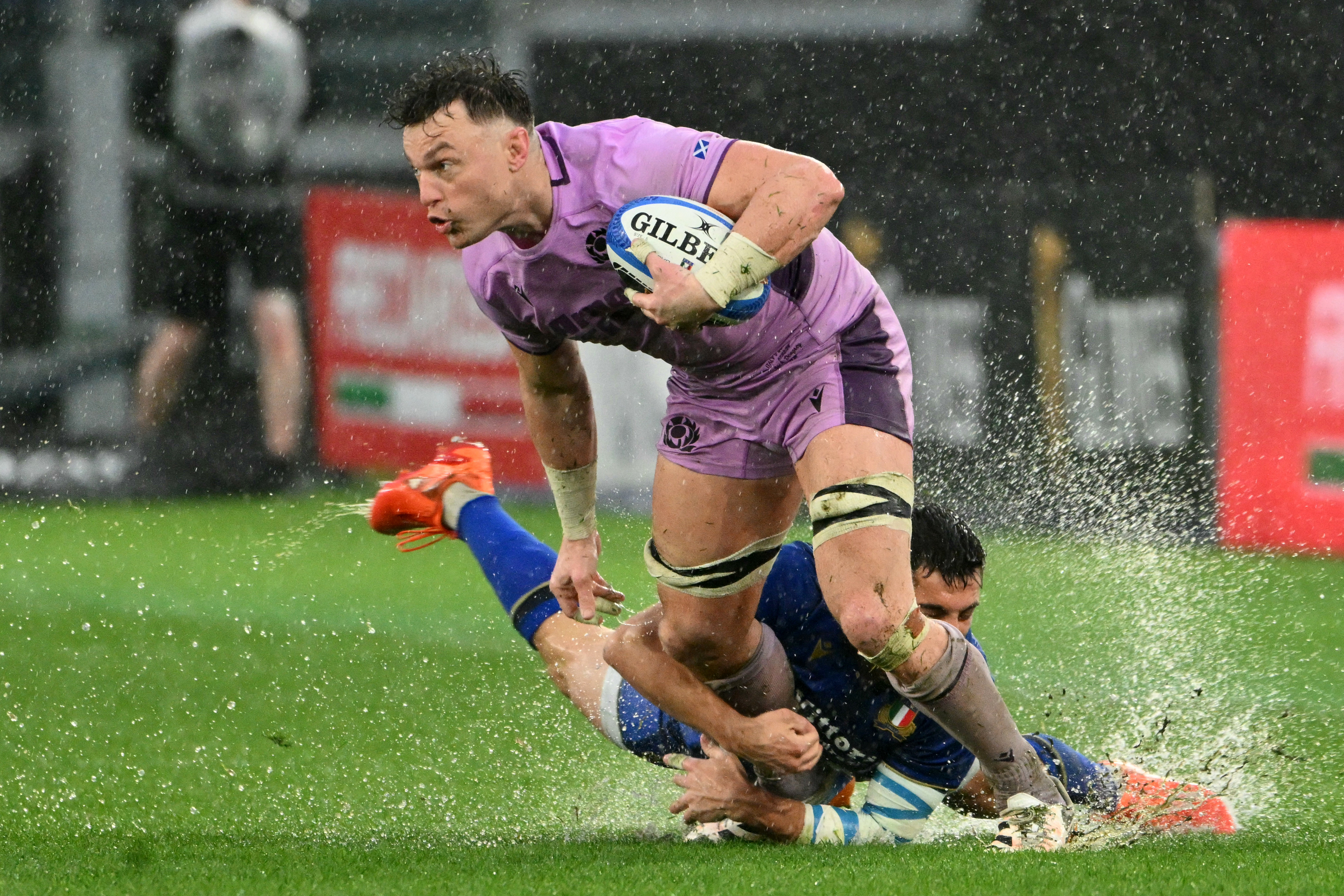Italy's #09 Alessandro Fusco and Scotland's number 8 #08 Jack Dempsey fight for the ball during a rugby match.
