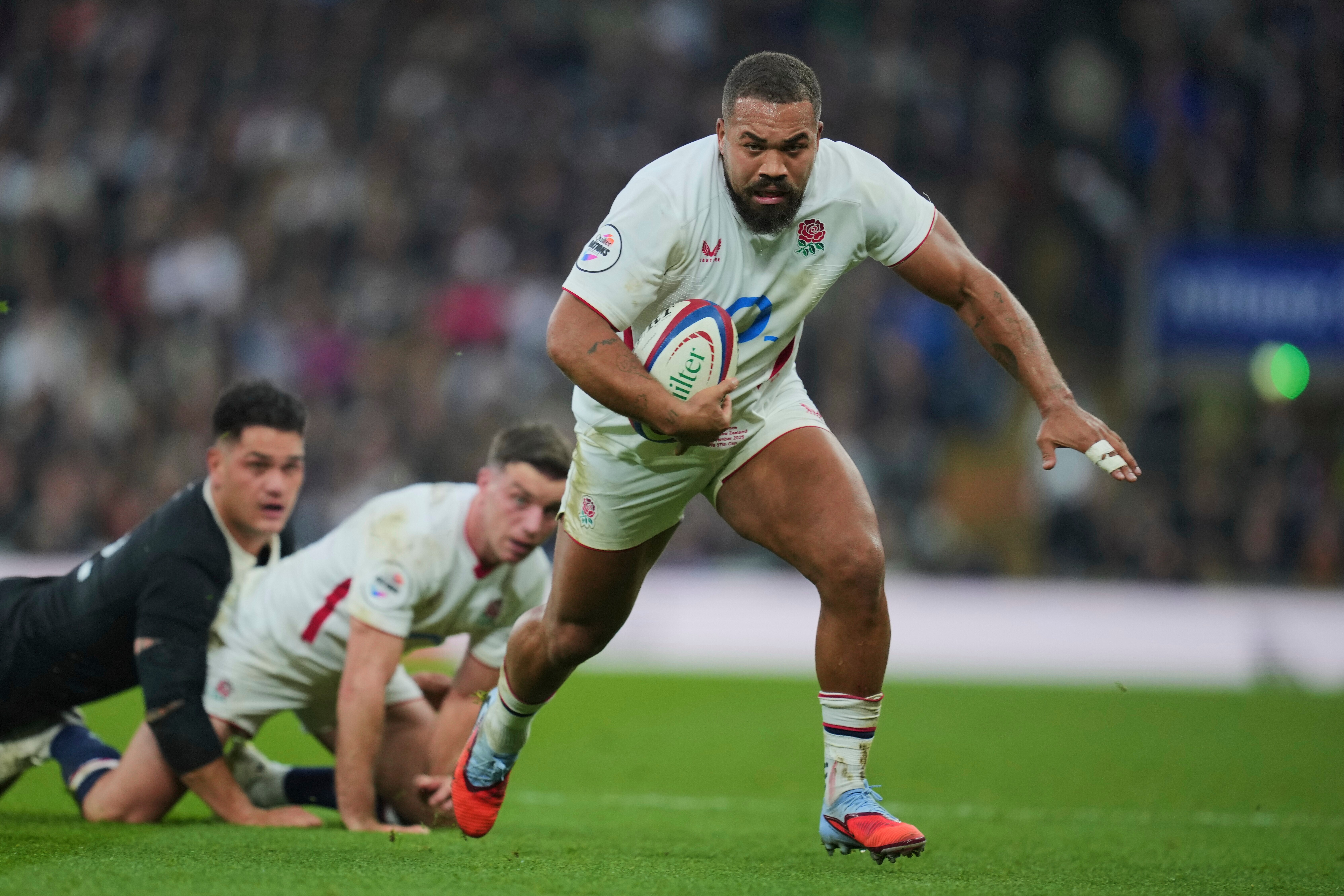 Ollie Lawrence breaks away to score a try during a rugby union match between England and New Zealand.