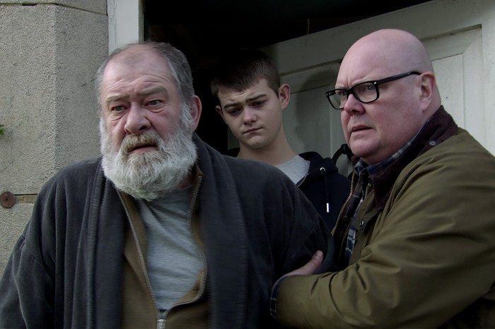 Bear, Dylan and Paddy stood in a doorway in a scene from Emmerdale