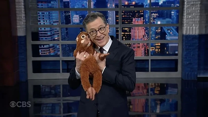 Stephen Colbert with Punch the monkey's IKEA DJUNGELSKOG orangutan toy 