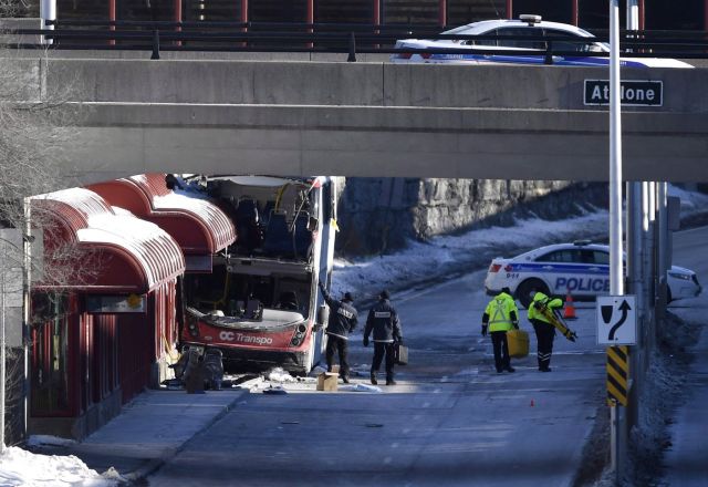 Officials from Transport Canada look at the scene where a double-decker city bus struck a transit shelter at Westboro Station in Ottawa on Saturday, Jan. 12, 2019. THE CANADIAN PRESS/Justin Tang