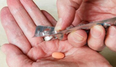 A photo of a man pushing a statin pill from its blisterpack.