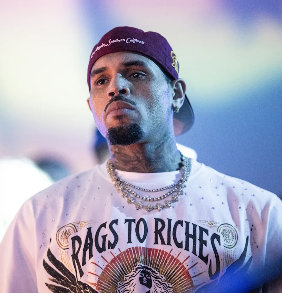 Chris Brown in a casual T-shirt and cap with layered necklaces at an event