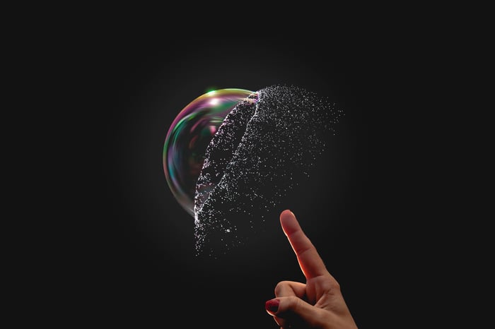 A bubble being popped by a finger.
