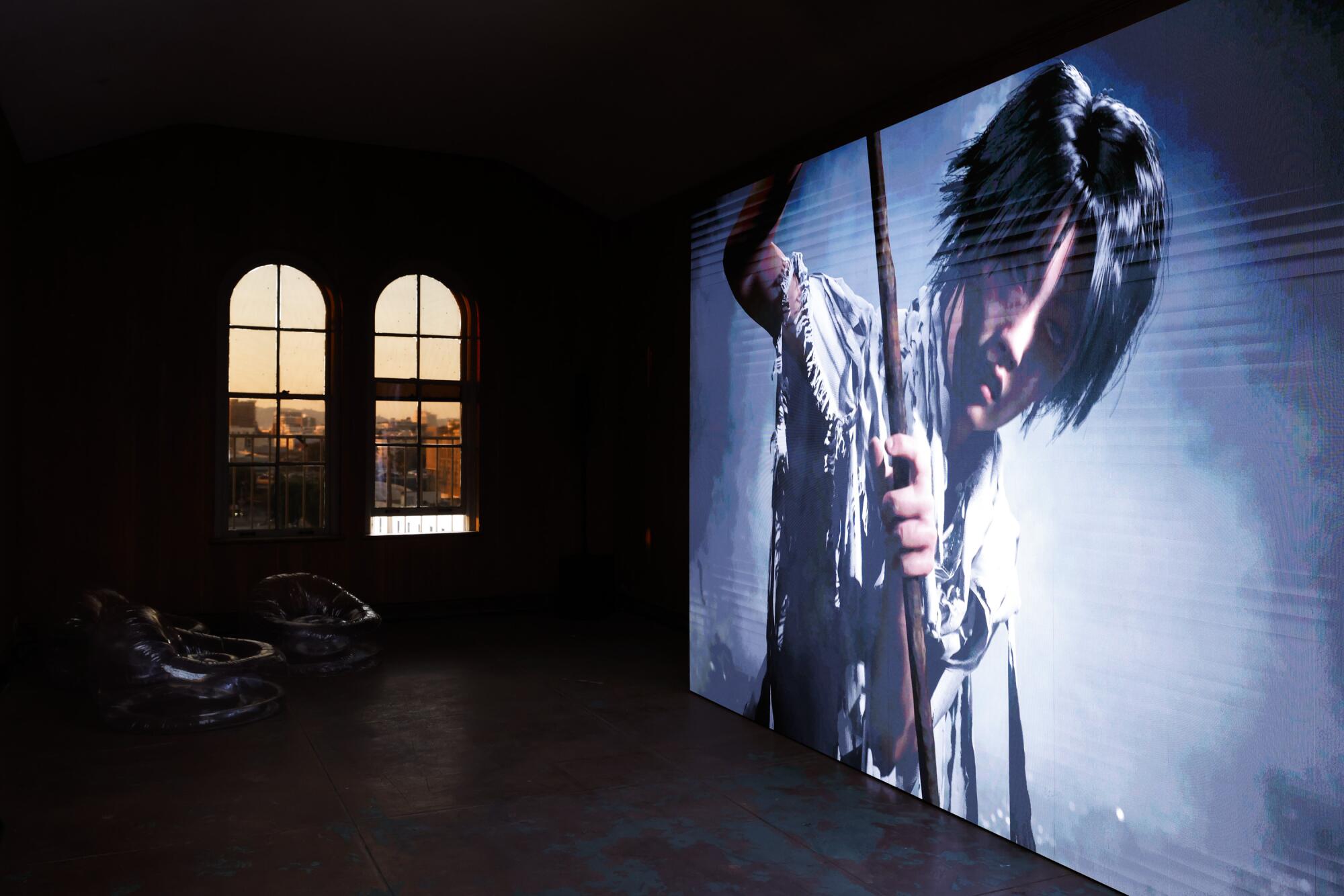 A film plays on a large screen in a dark room.
