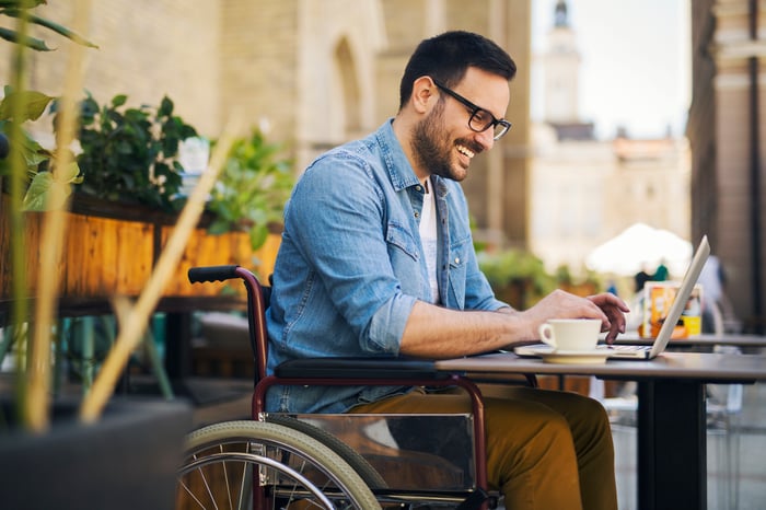 An investor smiles while working at a desk.