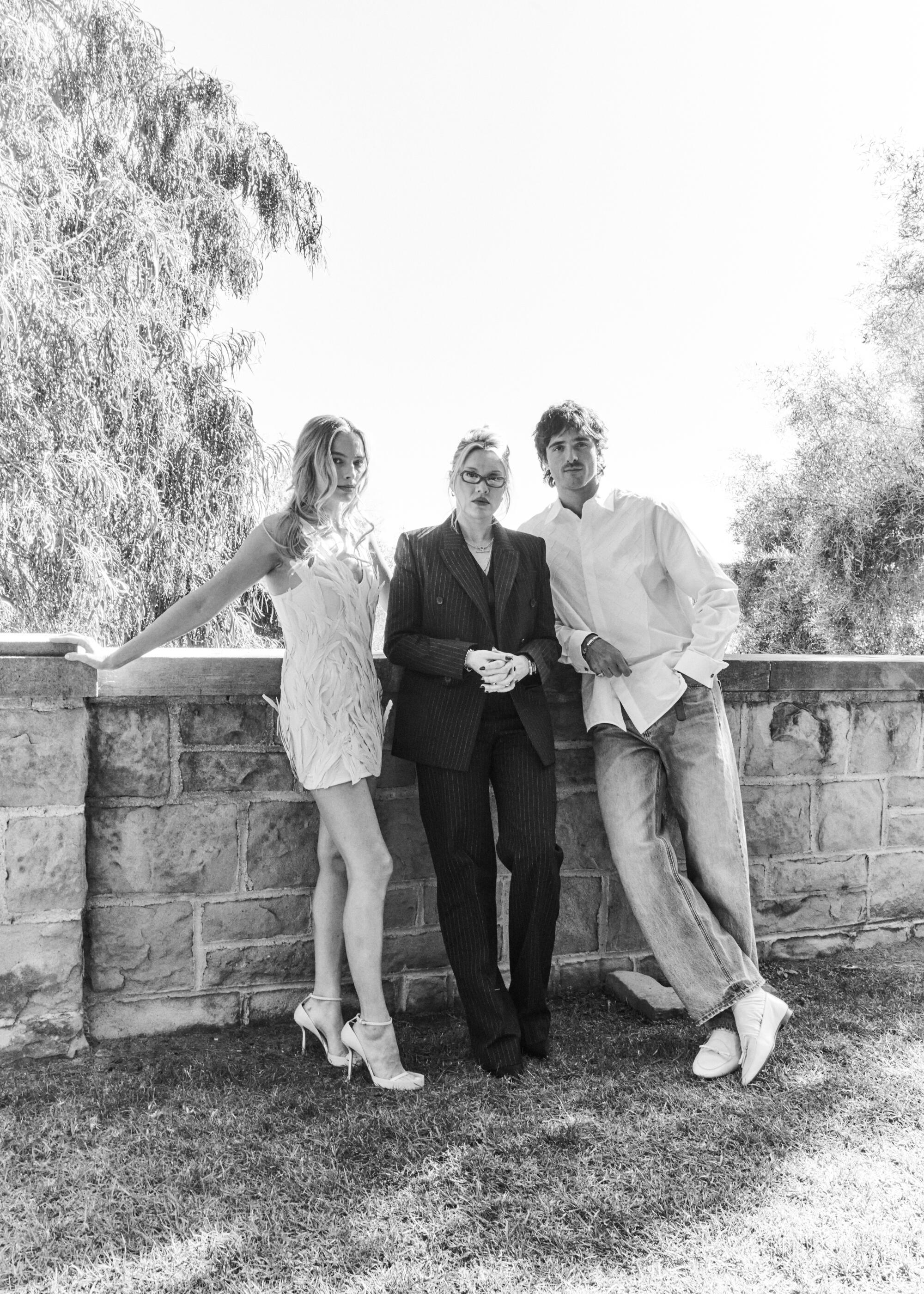 Three film collaborators stand outside on a stone landing.
