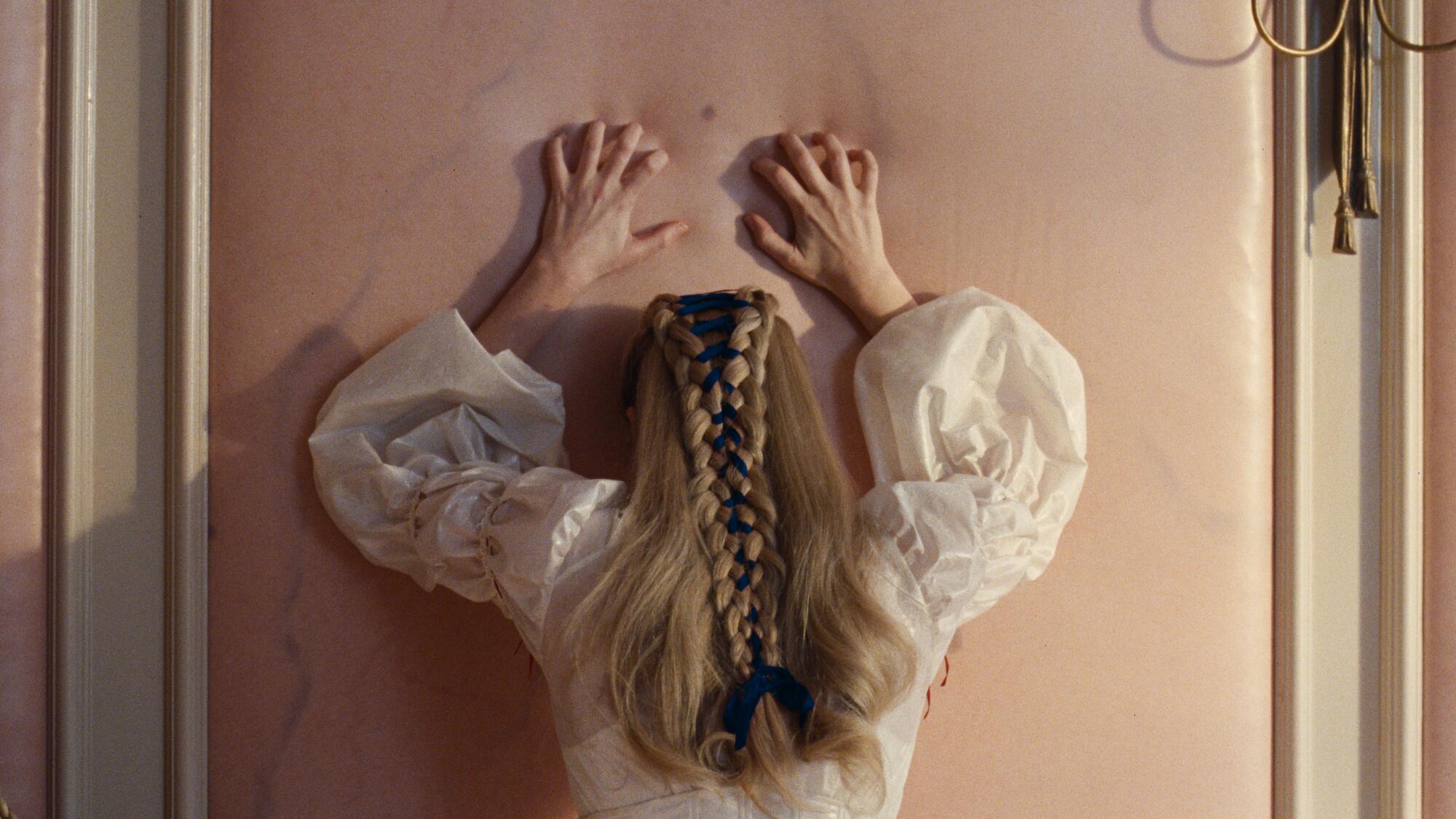 A woman leans against a veiny wall.