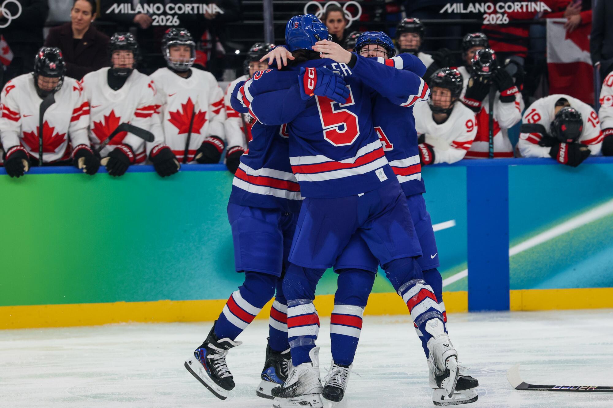 Megan Keller is mobbed by teammates after scoring the game winning goal in the Women's ice hockey final.