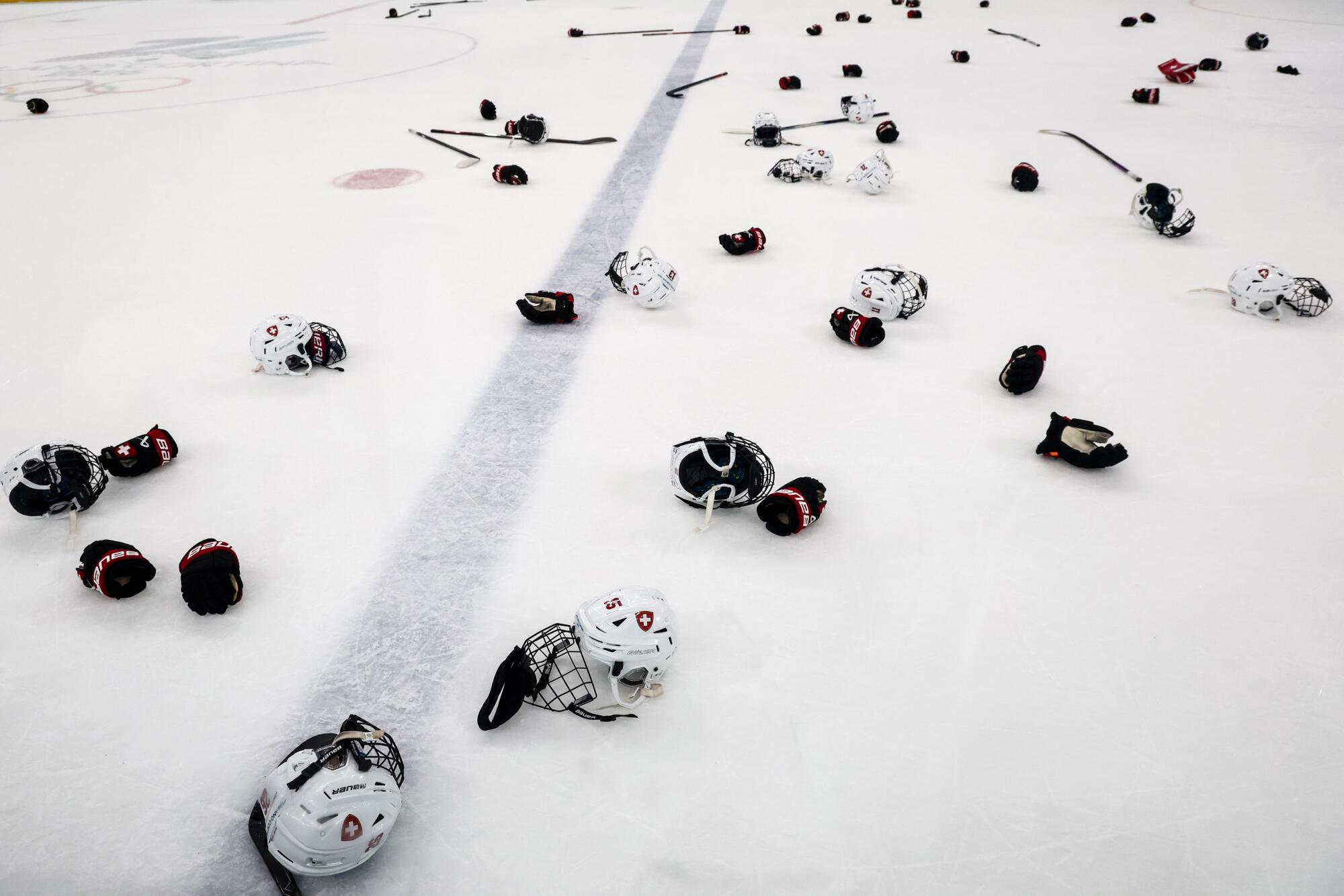 The Swiss Women's ice hockey team leaves their equipment on the ice following the Bronze Medal match.