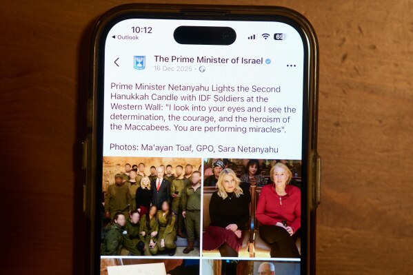 A Facebook post of the Prime Minister of Israel with a retouched photo of the Prime Minister’s wife, Sara Netanyahu, is displayed on a phone in Ramat Gan, Israel, Jan, 9, 2026 (AP Photo/Oded Balilty)