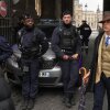 Pedro Elias Garzon Delvaux, right, walks past as police officers block an entrance to the Louvre after thieves carried out a daylight raid on French crown jewels, in Paris, Oct. 19, 2025.