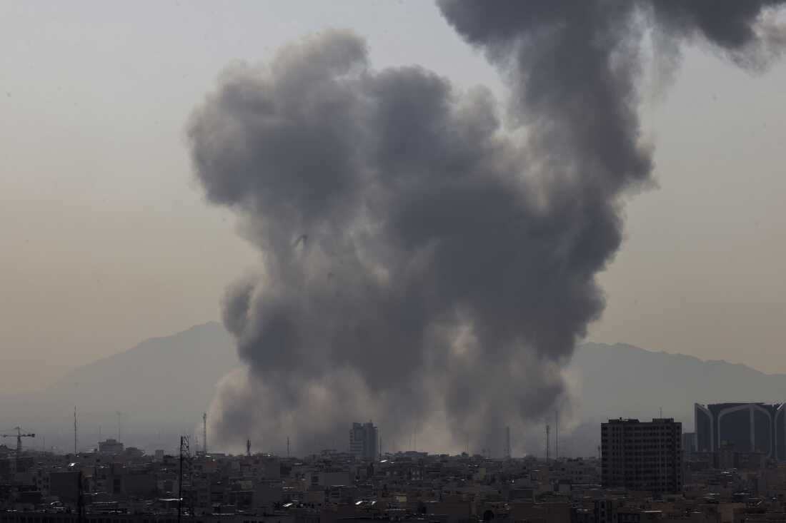 A plume of smoke rises following a reported explosion in Tehran on Saturday after U.S. and Israel launched strikes on Iran.