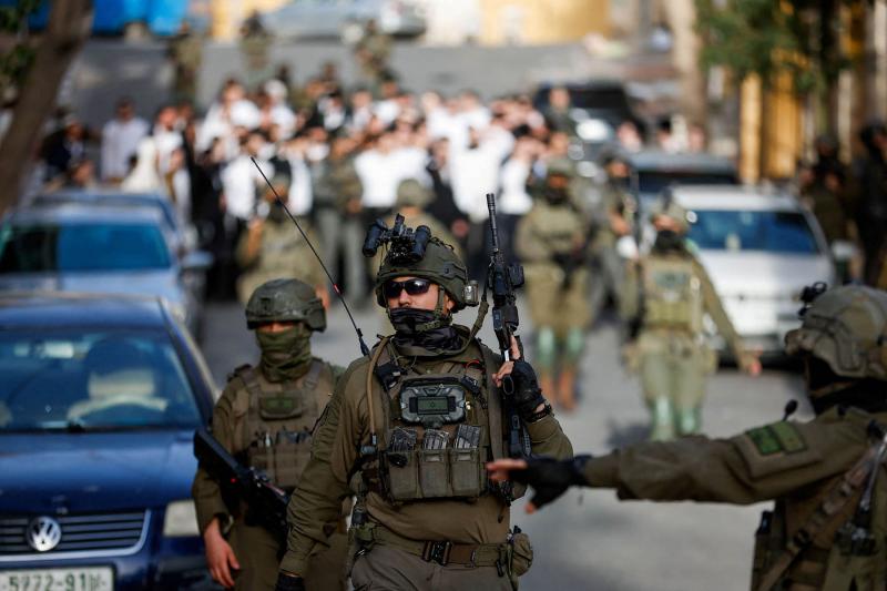 Israeli soldiers walk in front of a group of Israeli settlers, during “a weekly tour”, in Hebron, in the Israeli-occupied West Bank, January 31, 2026.