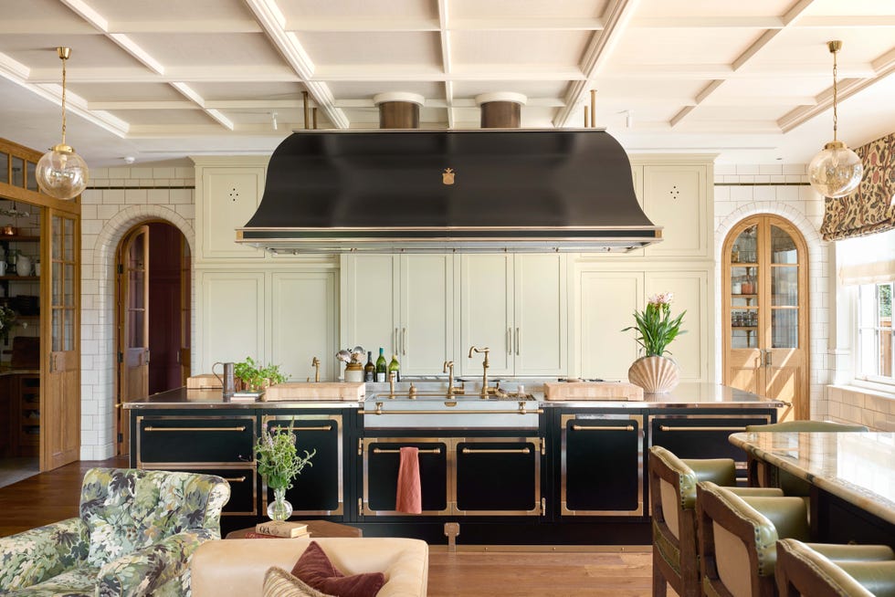 Modern kitchen featuring a central island with a prominent hood and stylish decor.