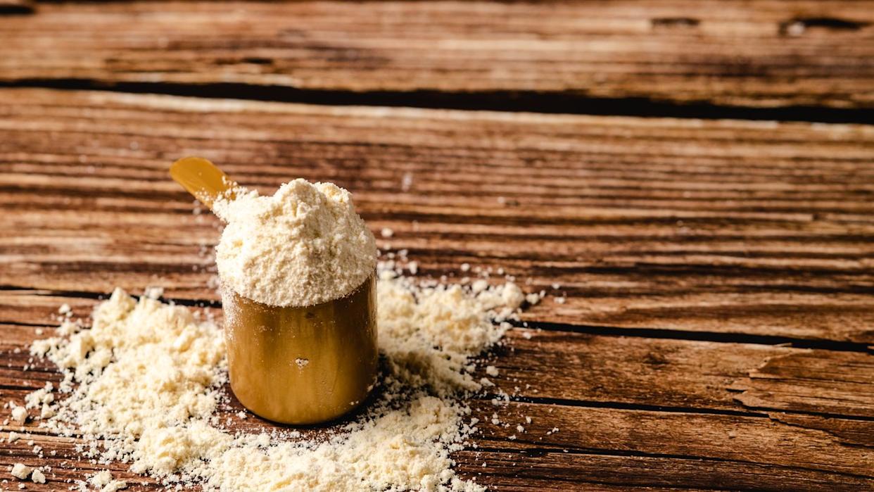 whey protein scoop powder on wood background,copy space