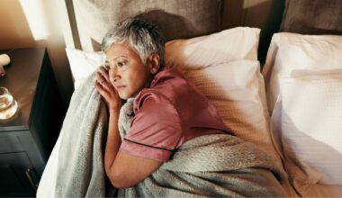 woman lays awake on bed unable to sleep