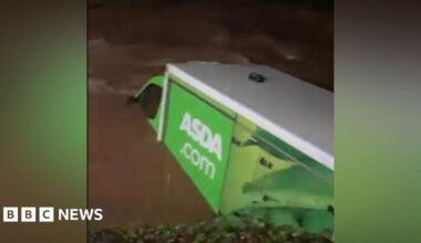 An aerial image shows a flooded road surrounded by standing water in a rural setting with trees, greenery and more floodwater in the background, in Hampshire on Friday.