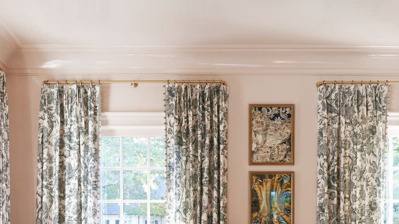 a living room with a red couch and a table with a vase of flowers