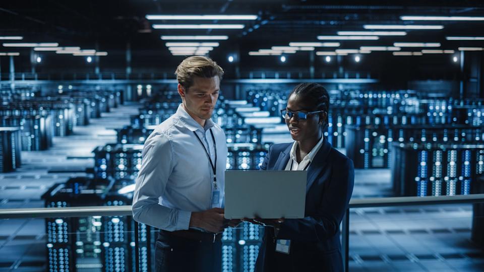 Two engineers overlooking a data center filled with GPUs.
