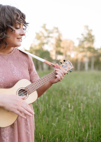 Angie Killian, composer of "Anytime, anywhere," plays her ukulele in Payson Canyon, 2024.