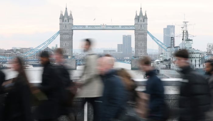 Workers cross London Bridge during the morning rush hour with Tower Bridge seen behind, in London, Britain, December 16, 2025. — Reuters