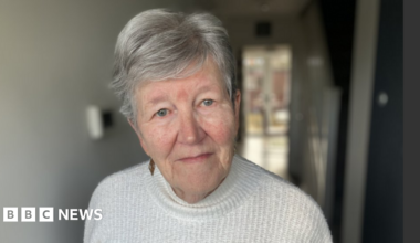 Sheila Jeffrey looking into the camera. She has short grey hair and is wearing a white jumper.
