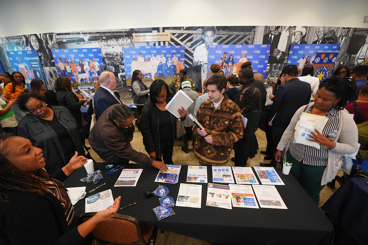 Job seekers listen for information on employment during a hiring fair at Fair Park in Dallas, Wednesday, Jan. 14, 2026. (AP Photo/LM Otero)