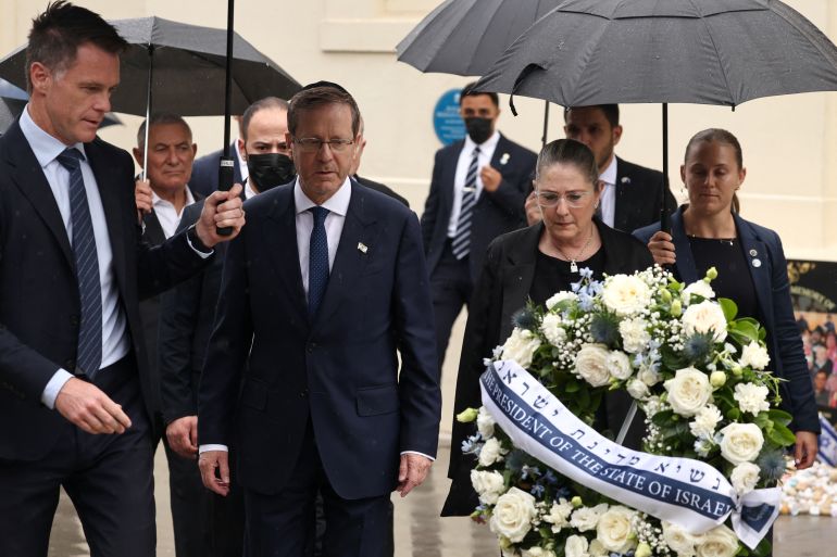 Israelli President Isaac Herzog (C) and his wife Michal (2nd R) are escorted by New South Wales Premier Chris Minns (L) as they lay a wreath for the victims of the December 14, 2025 gun attack at the Bondi Pavilion, in Sydney on February 9, 2026. Herzog said February 9 people of all faiths will "overcome this evil" as he paid respect to victims of a shooting that killed 15 people celebrating a Jewish festival on Sydney's Bondi Beach. (Photo by David GRAY / AFP)