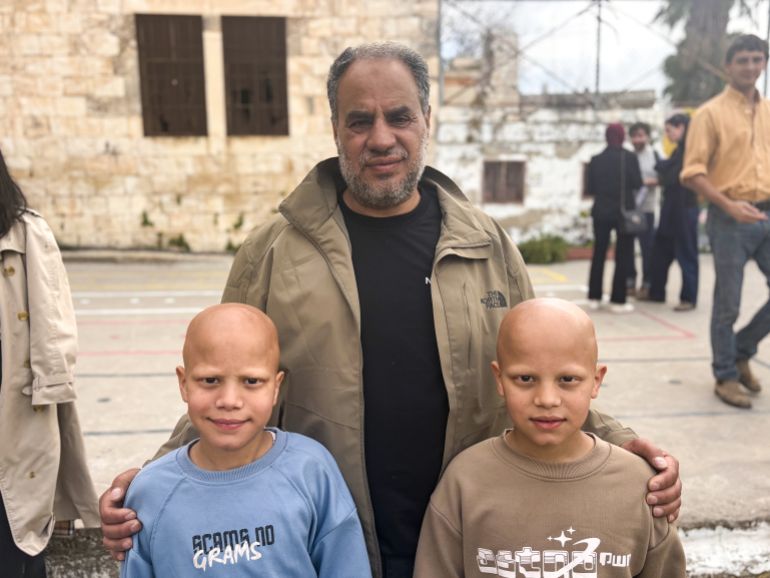 Abu Zaid al-Hajj with his twin sons, Muhammad and Ahmed, age 10 [Al Jazeera]