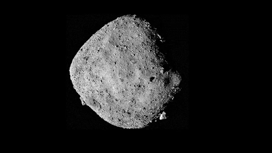 A diamond shaped asteroid Bennu. The surface is covered in small boulders.