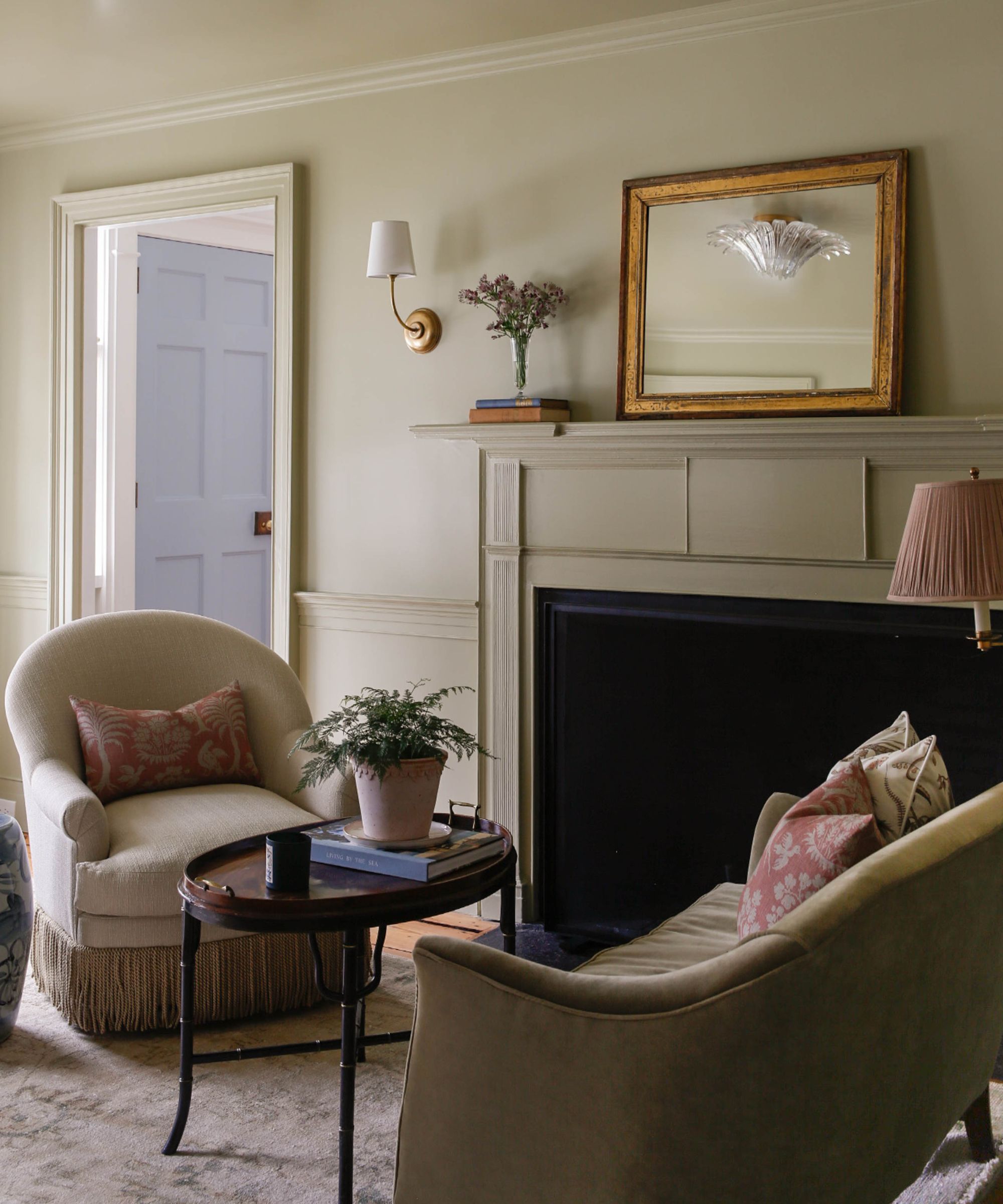 a soft neutral transition space with a group of traditional chairs set around a fireplace